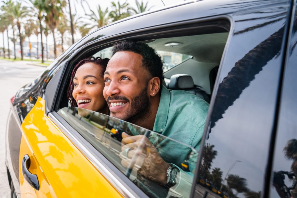 Happy hispanic latino couple taking a taxi